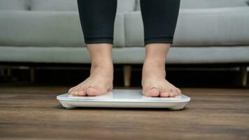 feet standing on electronic scales for weight control. Measurement instrument in kilogram for a diet control photo