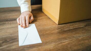 Business woman sending resignation letter and packing Stuff Resign Depress or carrying business cardboard box by desk in office. Change of job or fired from company photo