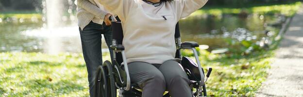 enfermería hogar. joven cuidador Ayudar mayor mujer en silla de ruedas. foto