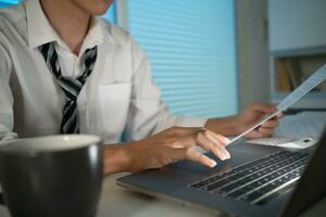 Asian businessman working on laptop in night office. dark late night at home office online meeting work hard concept. photo