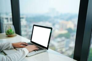 mujer trabajando por utilizando ordenador portátil blanco pantalla computadora . manos mecanografía en un tecnología de teclado comercio electrónico concepto. foto