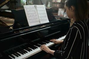 Beautiful woman playing piano, learn to play piano. photo