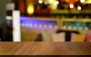 Empty dark wooden table in front of abstract blurred bokeh background of restaurant . can be used for display or montage your products.Mock up for space. photo