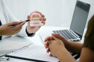 Dentist examining a patient teeth medical treatment at the dental office photo