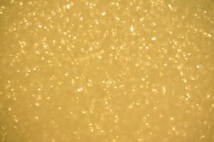 Gold glitters background. shimmering blur spot lights Bokeh Shiny gold light background. photo