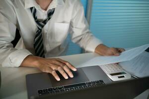 Asian businessman working on laptop in night office. dark late night at home office online meeting work hard concept. photo