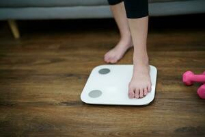 Fat diet and scale feet standing on electronic scales for weight control. Measurement instrument in kilogram for a diet control photo