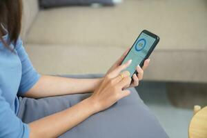 Woman controlling smart home. mobile phone with smart home app in living room. touch screen ai technology. Remote home control system. photo