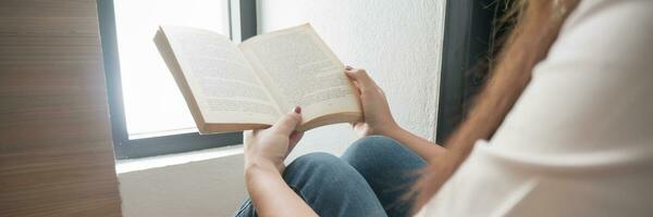 mujer leyendo libro y relajante a hogar y comodidad en frente de abrió libro. foto