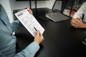 examinador leyendo un currículum durante trabajo entrevista a oficina negocio y humano recursos concepto. foto