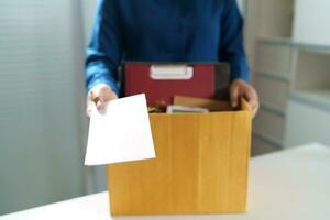 Quit Job Business man sending resignation letter and packing Stuff Resign Depress or carrying business cardboard box in office. Change of job or fired from company. photo
