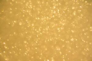 Gold glitters background. shimmering blur spot lights Bokeh Shiny gold light background. photo