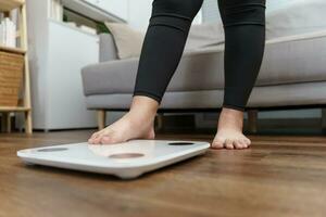 Fat diet and scale feet standing on electronic scales for weight control. Measurement instrument in kilogram for a diet control. photo
