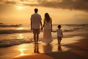 Happy family walking at the beach at sunset photo