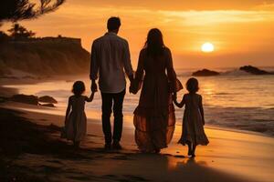 Happy family walking at the beach at sunset photo