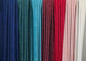 Detailed close up view on samples of cloth and fabrics in different colors found at a fabrics market photo