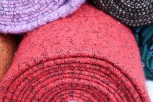 Detailed close up view on samples of cloth and fabrics in different colors found at a fabrics market photo