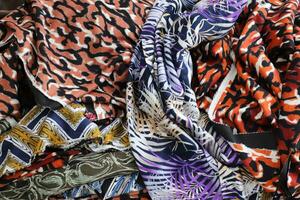 Detailed close up view on samples of cloth and fabrics in different colors found at a fabrics market photo