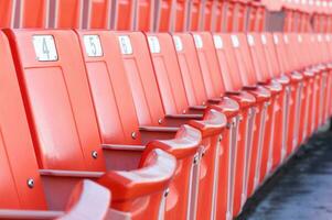 vacío naranja asientos a estadio,filas de asiento en un fútbol estadio foto