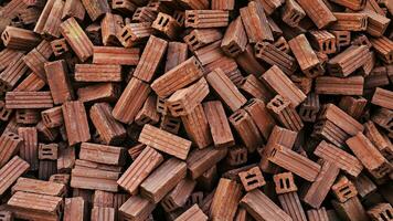 Red bricks are piled in large numbers to prepare for the construction of various buildings. Stack of red clay bricks for construction site photo