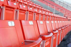 Empty orange seats at stadium,Rows of seat on a soccer stadium photo