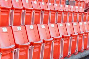 Empty orange seats at stadium,Rows of seat on a soccer stadium photo