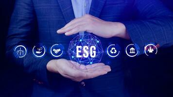 ESG icon concept in the hand for environmental, social and governance in sustainable and ethical business on the Network connection, businessman pressing button on screen. photo
