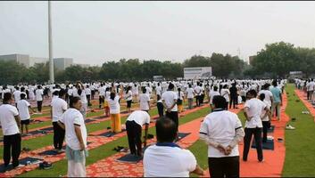 ny delhi, Indien, juni 21, 2023 - grupp yoga övning session för människor på yamuna sporter komplex i delhi på internationell yoga dag, stor grupp av vuxna delta yoga klass i cricket stadion video