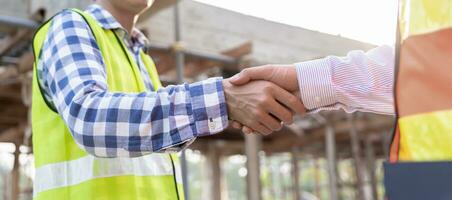 Construction worker team hands shaking greeting start up plan new project contract in office center at construction site, industry ,architecture, partner, teamwork, agreement, property, contacts. photo