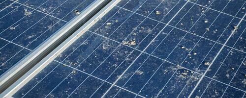 Upper surface of solar rooftop which has been used for a long time is stained with dust, bird droppings, dirt, smog and rainwater stains, concept for cleaning, washing and maintainance, cropped shot. photo