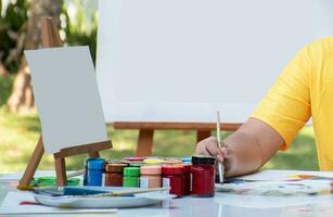 aprendizaje el Arte de dibujo y pintura fuera de el salón de clases por practicando mezcla póster colores de júnior alto colegio estudiantes en el mesa. foto