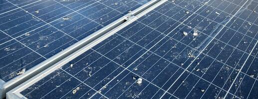 Upper surface of solar rooftop which has been used for a long time is stained with dust, bird droppings, dirt, smog and rainwater stains, concept for cleaning, washing and maintainance, cropped shot. photo