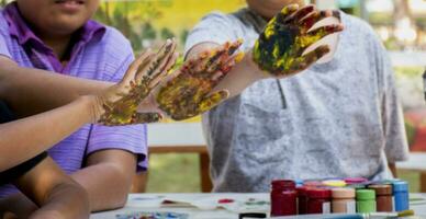 Hands of junior high school boys stained with different colors during an art lesson outside the classroom. photo