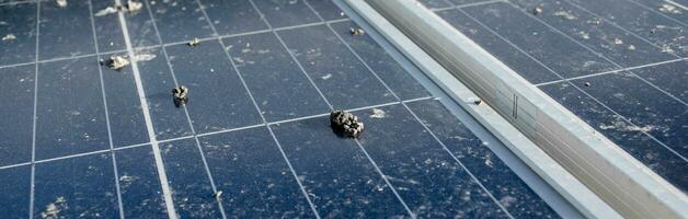 Upper surface of solar rooftop which has been used for a long time is stained with dust, bird droppings, dirt, smog and rainwater stains, concept for cleaning, washing and maintainance, cropped shot. photo