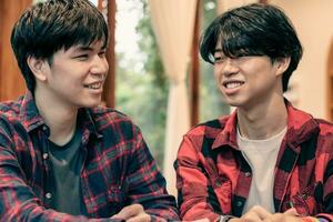 asian young adult couple spending their free times by talking and consulting their daily life problems in coffee shop, happy life, gender diversity and teenagers lifestyle concept. photo