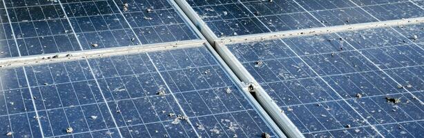 Upper surface of solar rooftop which has been used for a long time is stained with dust, bird droppings, dirt, smog and rainwater stains, concept for cleaning, washing and maintainance, cropped shot. photo