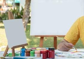 aprendizaje el Arte de dibujo y pintura fuera de el salón de clases por practicando mezcla póster colores de júnior alto colegio estudiantes en el mesa. foto