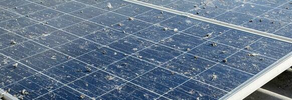 Upper surface of solar rooftop which has been used for a long time is stained with dust, bird droppings, dirt, smog and rainwater stains, concept for cleaning, washing and maintainance, cropped shot. photo