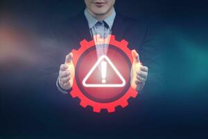 Businessman showing warning triangle notification showing system error. Concepts of system maintenance, security, anti-virus and anti hacking access to critical data. photo