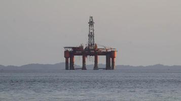 costa afuera petróleo plataforma perforación sitio o petróleo plataforma proyecto visto lejos en el medio de el mar. foto