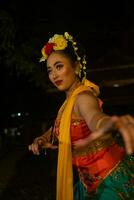 retrato de un tradicional sundanés bailarín bailando con un naranja bufanda colgando abajo su cuerpo foto