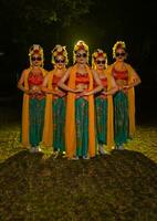 un grupo de indonesio tradicional bailarines danza con su amigos en frente de el etapa luces foto