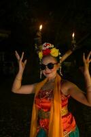 un indonesio tradicional bailarín bailes en Gafas de sol y un naranja disfraz con un hermosa chal foto