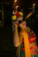 a traditional asian dancer poses with sunglasses while dancing on stage photo