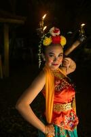 retrato de un javanés bailarín con flores en su cabeza y maquillaje en su hermosa cara foto