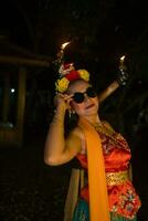 a traditional asian dancer poses with sunglasses while dancing on stage photo