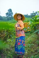 an Indonesian woman working as a tea plantation farmer wearing an orange shirt photo