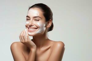 Woman smiling while applying moisturizing cream photo