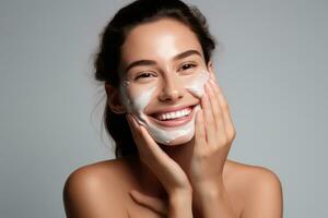 Woman smiling while applying moisturizing cream photo
