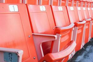 Empty orange seats at stadium,Rows of seat on a soccer stadium photo